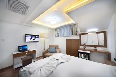 a bedroom with a bed and a desk and a television at Lika Hotel in Istanbul