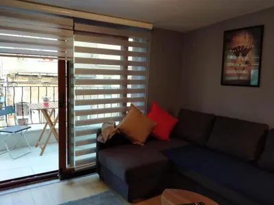 a living room with a couch and a large window at Oval Flats Old City in Istanbul