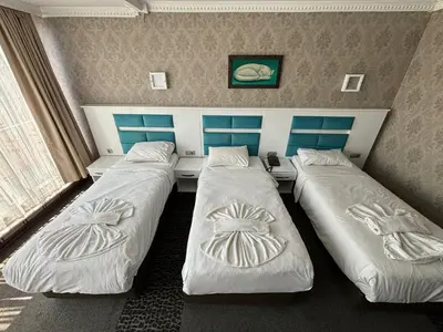 a room with three beds in a room at Comfort Downtown Istanbul Hotel in Istanbul