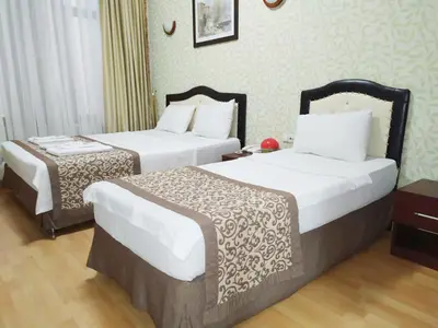 a hotel room with two beds with white sheets at Taxim Hotel Marin in Istanbul