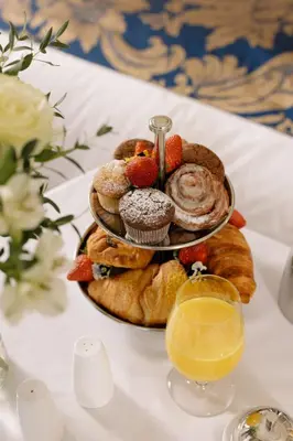 a plate of pastries on a table with a glass of orange juice at Hotel Gritti Pera & Spa in Istanbul