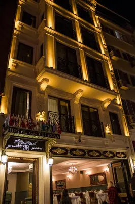 a building with people sitting on a balcony at night at Hotel Gritti Pera & Spa in Istanbul