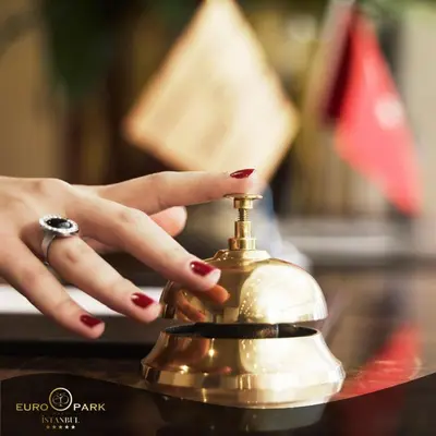 a woman with red nail polish holding a bell at Euro Park Otel in Istanbul