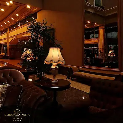 a living room with a couch and a table with a lamp at Euro Park Otel in Istanbul