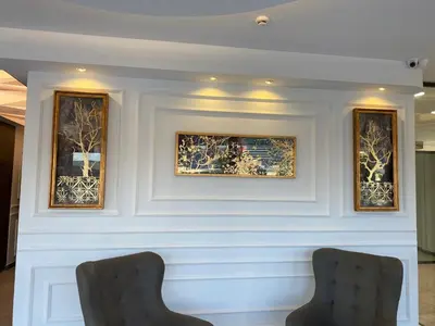 two chairs in front of a wall with paintings at Le Luxe Suites Hotel in Bursa