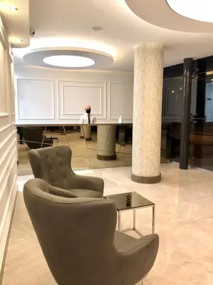 a person standing in a lobby with chairs and a table at Le Luxe Suites Hotel in Bursa