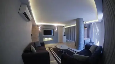 a living room with couches and a table and a tv at Le Luxe Suites Hotel in Bursa