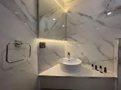 a white bathroom with a sink and a mirror at Le Luxe Suites Hotel in Bursa