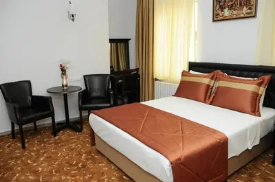 a bedroom with a bed and a table and chairs at Hotel Kuk in Istanbul