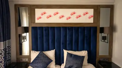 a bed with a blue head board with red flowers on it at Farina Hotel By Cigno in Istanbul