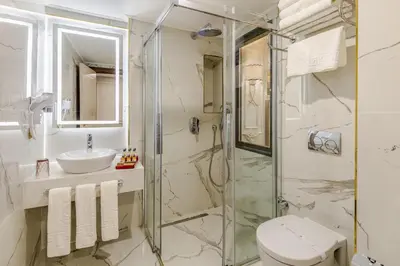 a bathroom with a shower and a toilet and a sink at Beethoven Senfoni Hotel in Istanbul