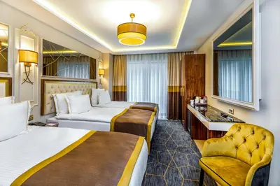 a hotel room with two beds and a chair at Beethoven Senfoni Hotel in Istanbul