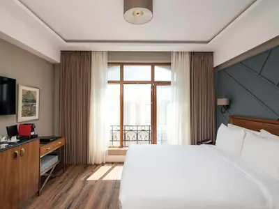 a bedroom with a large bed and a large window at Azzap Hotel Galata in Istanbul