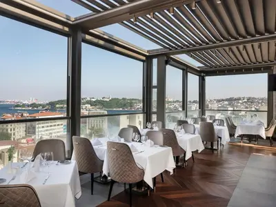 a restaurant with white tables and chairs and large windows at Azzap Hotel Galata in Istanbul