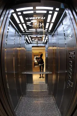 a woman taking a picture of a hallway in a elevator at X-NELLYİ HOTEL in Istanbul
