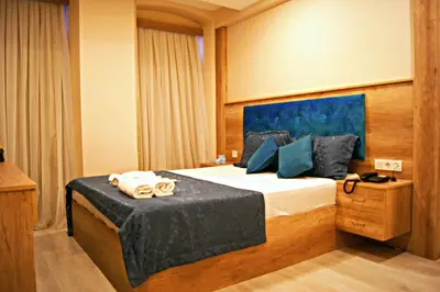 a bedroom with a bed with a blue head board at Destinia Pera in Istanbul