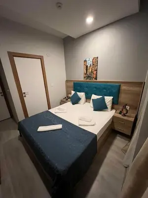 a bedroom with a large bed with a blue headboard at Destinia Pera in Istanbul