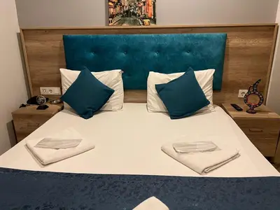 a large bed with two pillows and a blue headboard at Destinia Pera in Istanbul