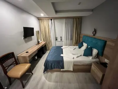a bedroom with a bed and a chair and a television at Destinia Pera in Istanbul