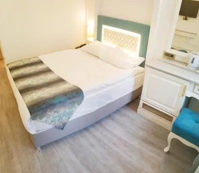 a bedroom with a bed and a blue chair at Ligos in Istanbul