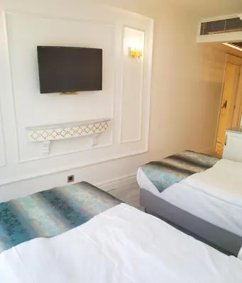 a hotel room with two beds and a flat screen tv at Ligos in Istanbul