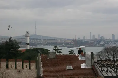 a bird flying over a brick building with a lighthouse at Ligos in Istanbul