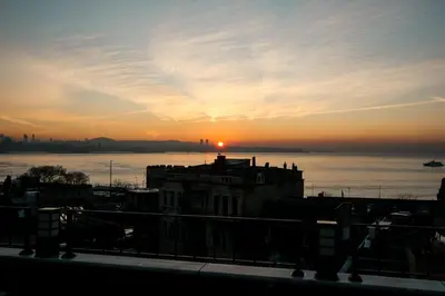 a sunset over the water with a building in the foreground at Ligos in Istanbul