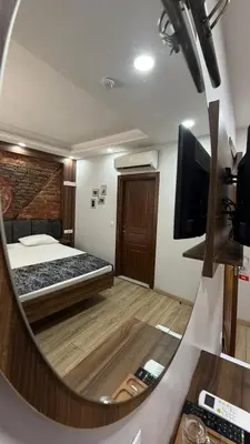 a mirror reflecting a bedroom with a bed and a television at Han Suite Hotel in Istanbul