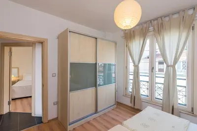 a living room with a large window and a bedroom at Istanbul Amedros Home in Istanbul