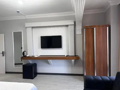 a living room with a tv on a wall at KILIÇ MOTEL in Istanbul