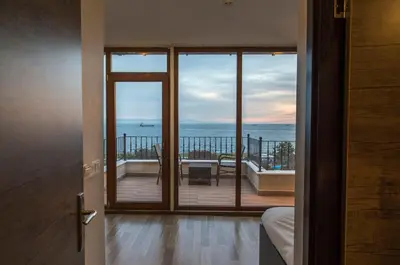 a room with a balcony with a view of the ocean at Cheers Lighthouse in Istanbul