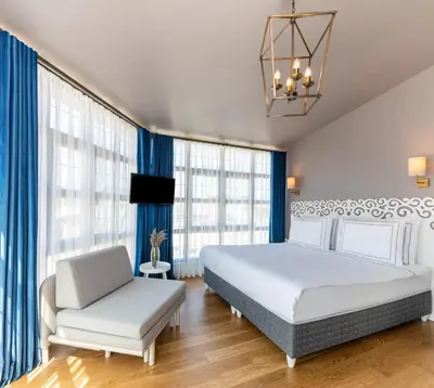 a bedroom with a white bed and a chair at Petros Hotel in Istanbul