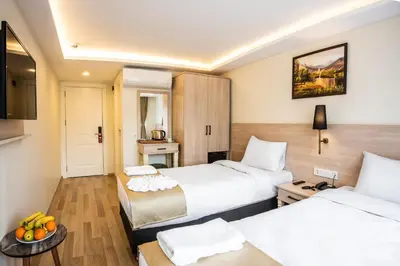 a hotel room with two beds and a table at Royal Bosphorus Hotel & SPA Hamam in Istanbul