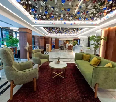 a lobby with a green couch and chairs and a table at Vital Hotel Fulya Istanbul Sisli in Istanbul