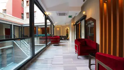 a corridor of a building with red chairs and a balcony at Grand Sirkeci Hotel in Istanbul