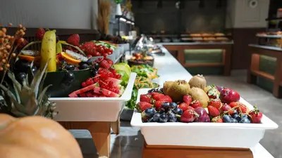 two white trays of fruits and vegetables on a table at Grand Sirkeci Hotel in Istanbul