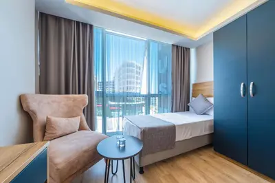 a bedroom with a bed and a chair and a window at RUSH HOTEL İSTANBUL in Istanbul
