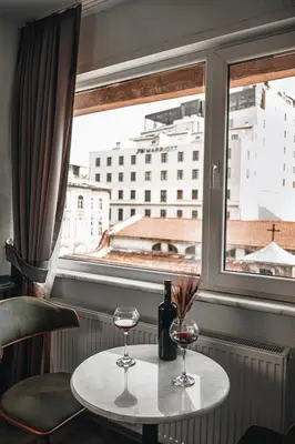 a table with two glasses of wine and a window at PANDAN KARAKOY SUİT in Istanbul