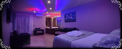 a bedroom with purple lighting and a bed and a bathroom at Senler Boutique Hotel in Sapanca