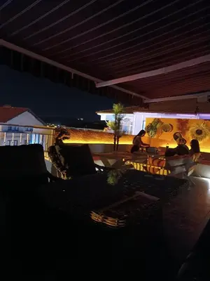a group of people sitting on a patio at night at Hotel Ipekyolu in Sapanca