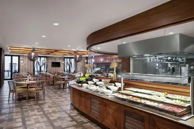a restaurant with a buffet line with tables and chairs at DoubleTree by Hilton Istanbul Gayrettepe in Istanbul