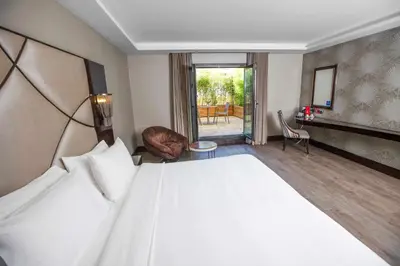 a bedroom with a large bed and a living room at DoubleTree by Hilton Istanbul Gayrettepe in Istanbul