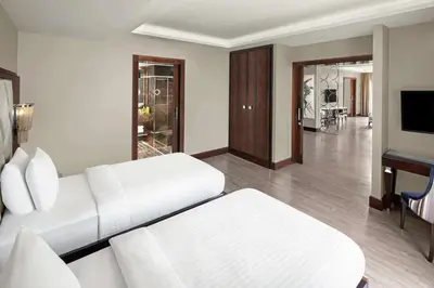 a living room with a white couch and a piano at DoubleTree by Hilton Istanbul Gayrettepe in Istanbul