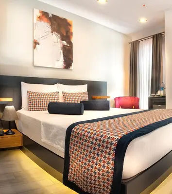 a bedroom with a large bed and a red chair at Ooda Rooms Kadıköy in Istanbul