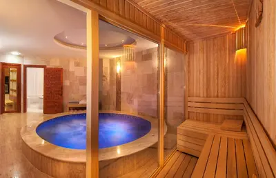 a jacuzzi tub in a wooden bathroom with a bench at Ooda Rooms Kadıköy in Istanbul