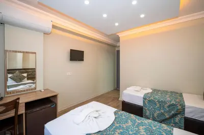 a hotel room with two beds and a mirror at Hotel Simper in Istanbul
