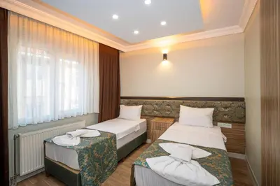 a hotel room with two beds and a window at Hotel Simper in Istanbul