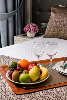 a plate of fruit on a table with two wine glasses at Four Sides Sisli in Istanbul