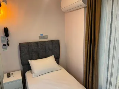 a small room with a bed with a white pillow at Zion Home Butik Otel in Istanbul