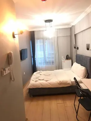 a bedroom with a bed and a desk and a phone at Zion Home Butik Otel in Istanbul